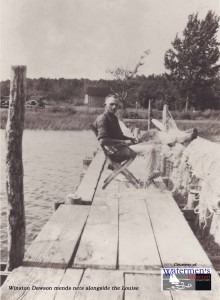 Winston Dawson mends nets alongside the Louise